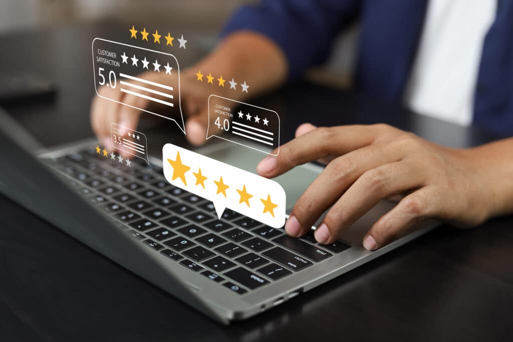 Une personne rempli un questionnaire de satisfaction à froid sur un ordinateur portable, avec des icônes flottantes représentant des évaluations par étoiles et des niveaux de satisfaction client.