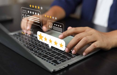 Une personne rempli un questionnaire de satisfaction à froid sur un ordinateur portable, avec des icônes flottantes représentant des évaluations par étoiles et des niveaux de satisfaction client.